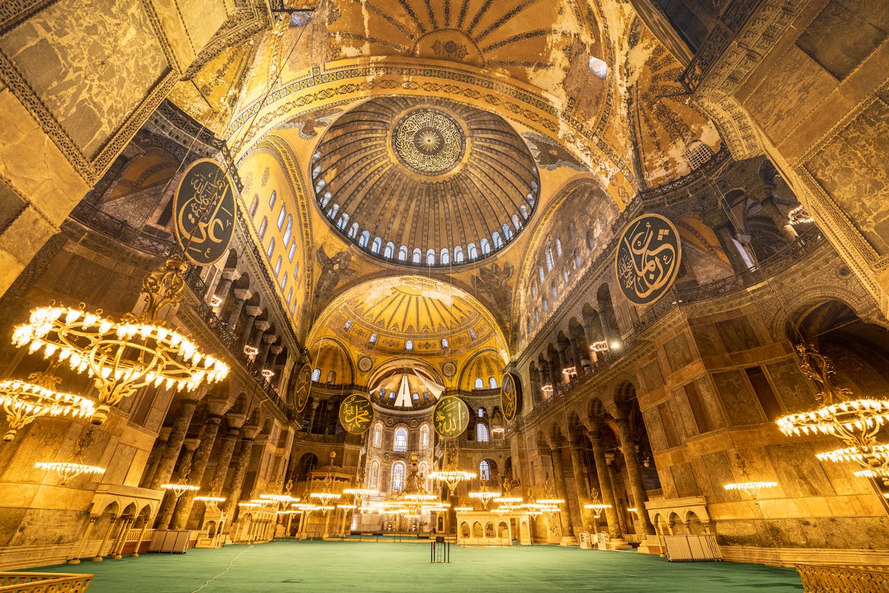 Stunning view of the illuminated interior of Hagia Sophia, showcasing its majestic dome and intricate design.