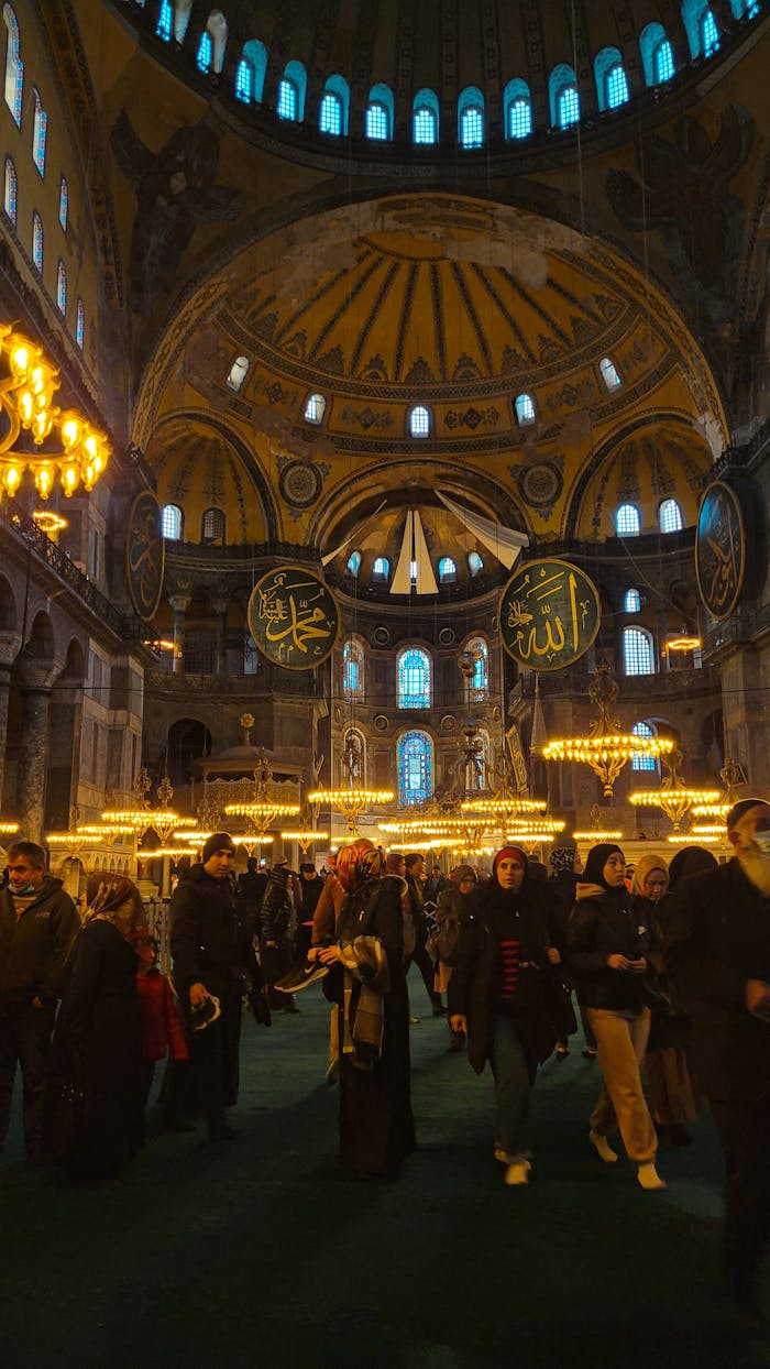 People inside the historic Hagia Sophia, showcasing its architectural grandeur in Istanbul, Turkey.