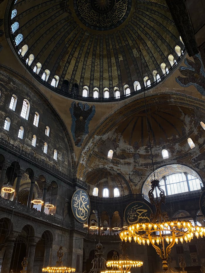 Explore the stunning interior architecture of Hagia Sophia in Istanbul with its grand dome and intricate chandeliers.